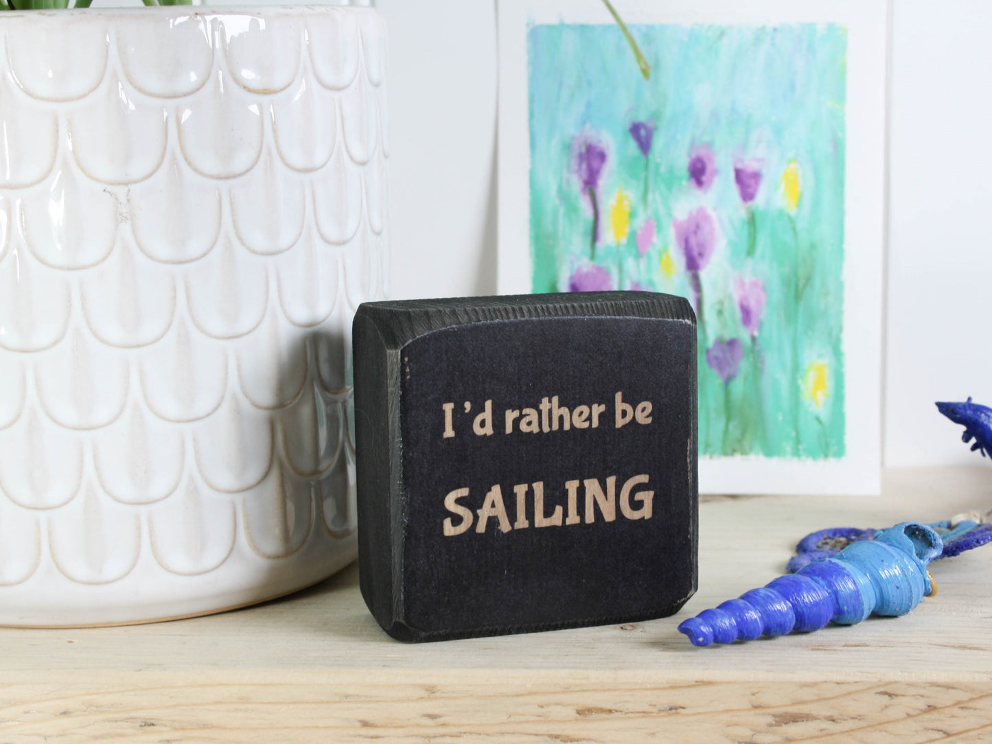 Small distressed black wood sign with the saying "I'd rather be sailing"