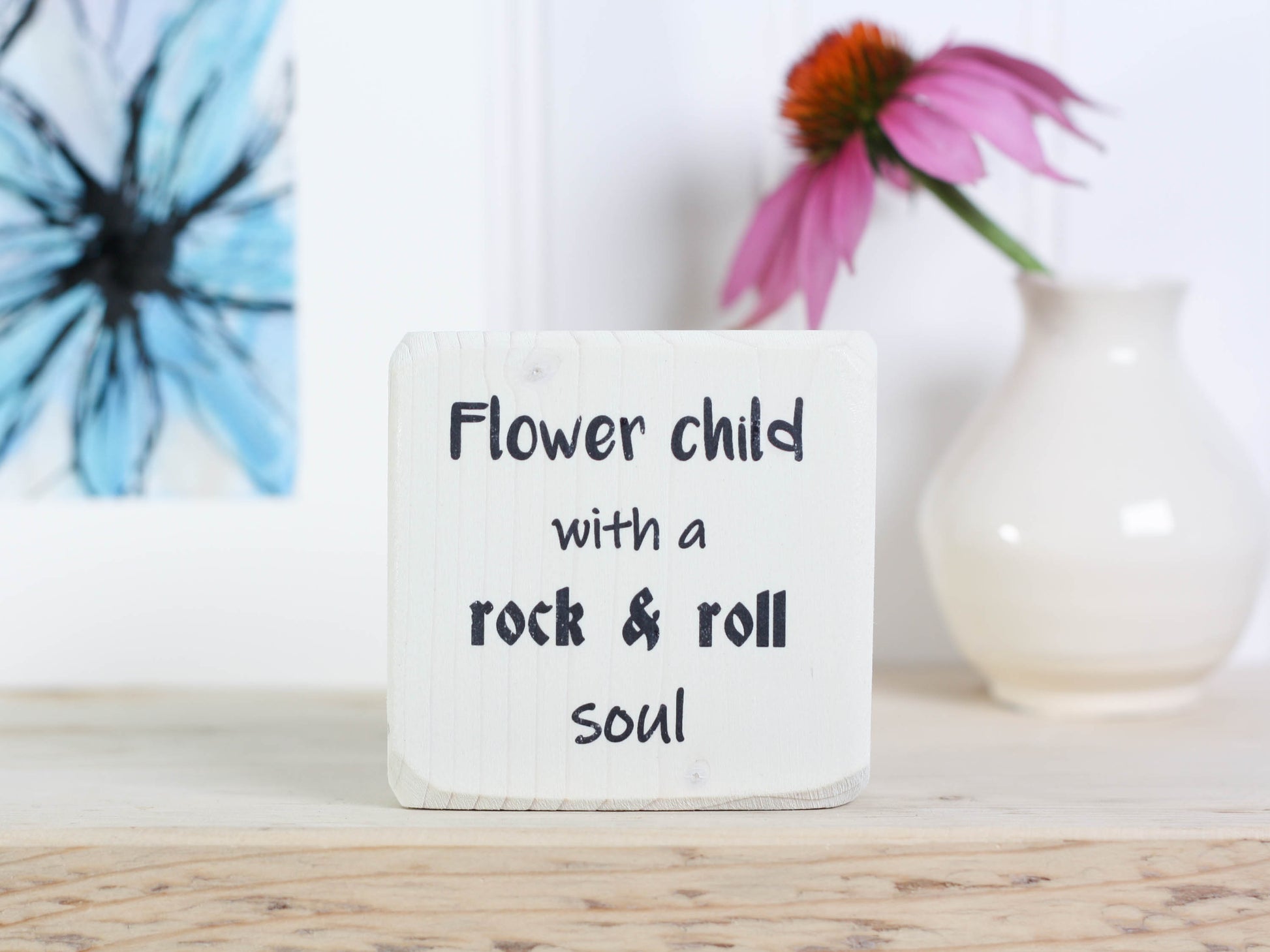 Small, freestanding, whitewash, solid wood sign with saying "Flower child with a rock & roll soul".