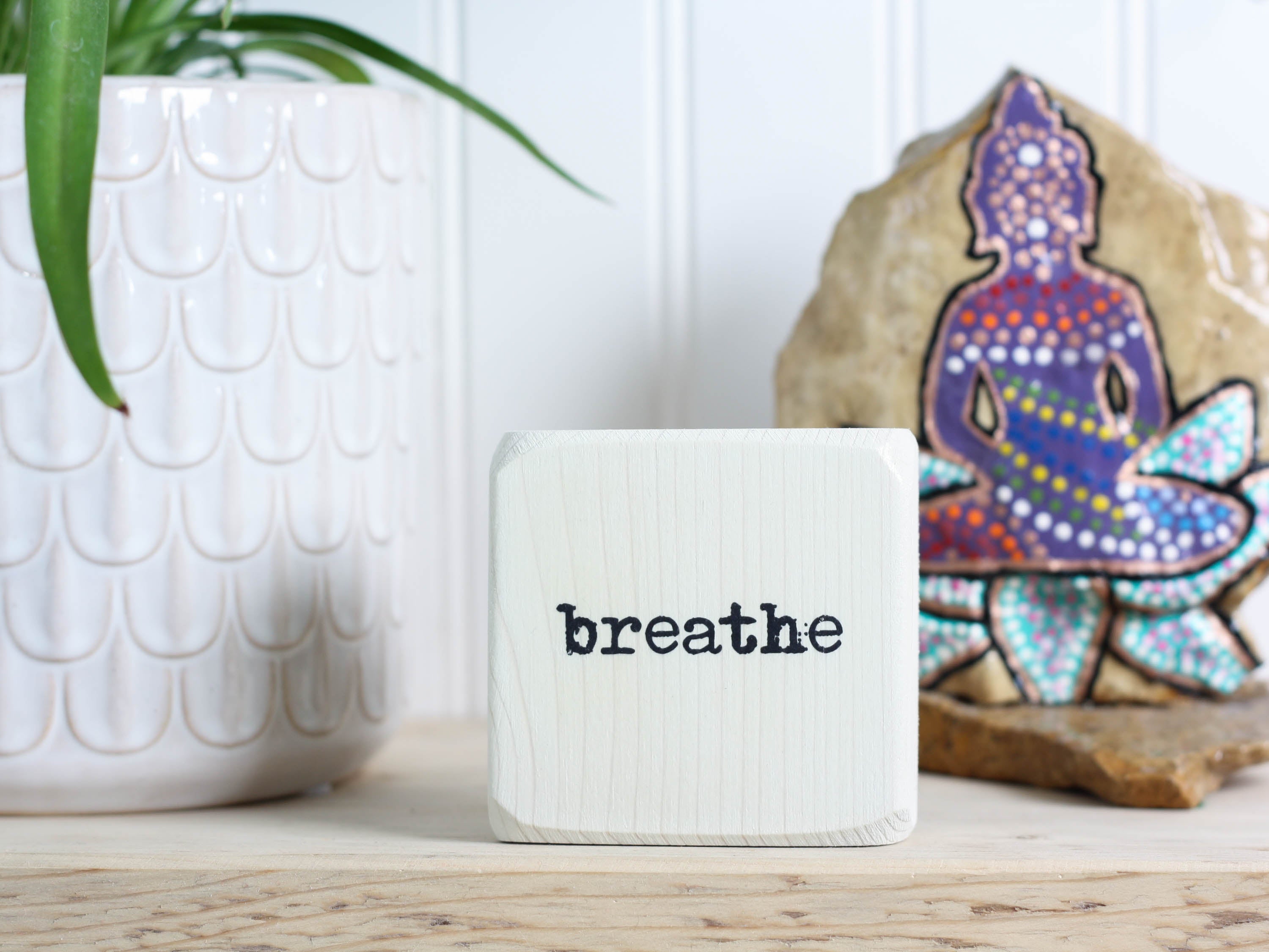 Small wood yoga meditation sign in whitewash with the word "Breathe".