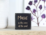 Mini wood sign in distressed black with the saying "Music is the voice of the soul."