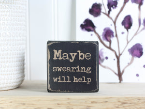 Small quote block in distressed black with the saying "Maybe swearing will help".