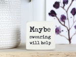 Small quote block in whitewash with the saying "Maybe swearing will help".