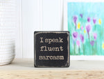 Mini wood sign in distressed black with the saying "I speak fluent sarcasm".