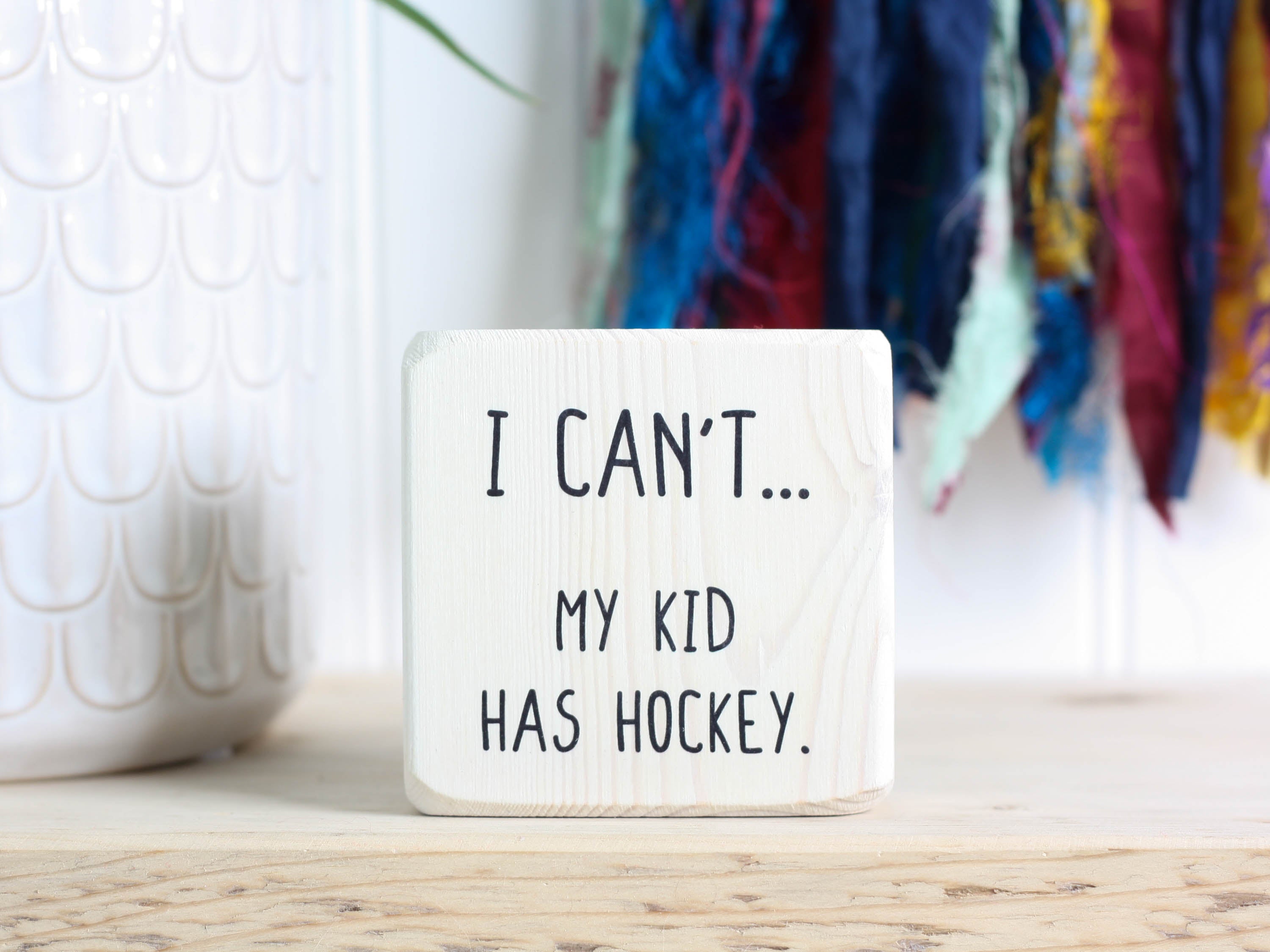 Mini whitewashed wood sign with the saying "I can't... my kid has hockey."