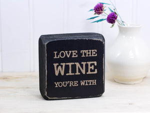 Mini wood bar sign in distressed black with the saying "Love the wine you're with".