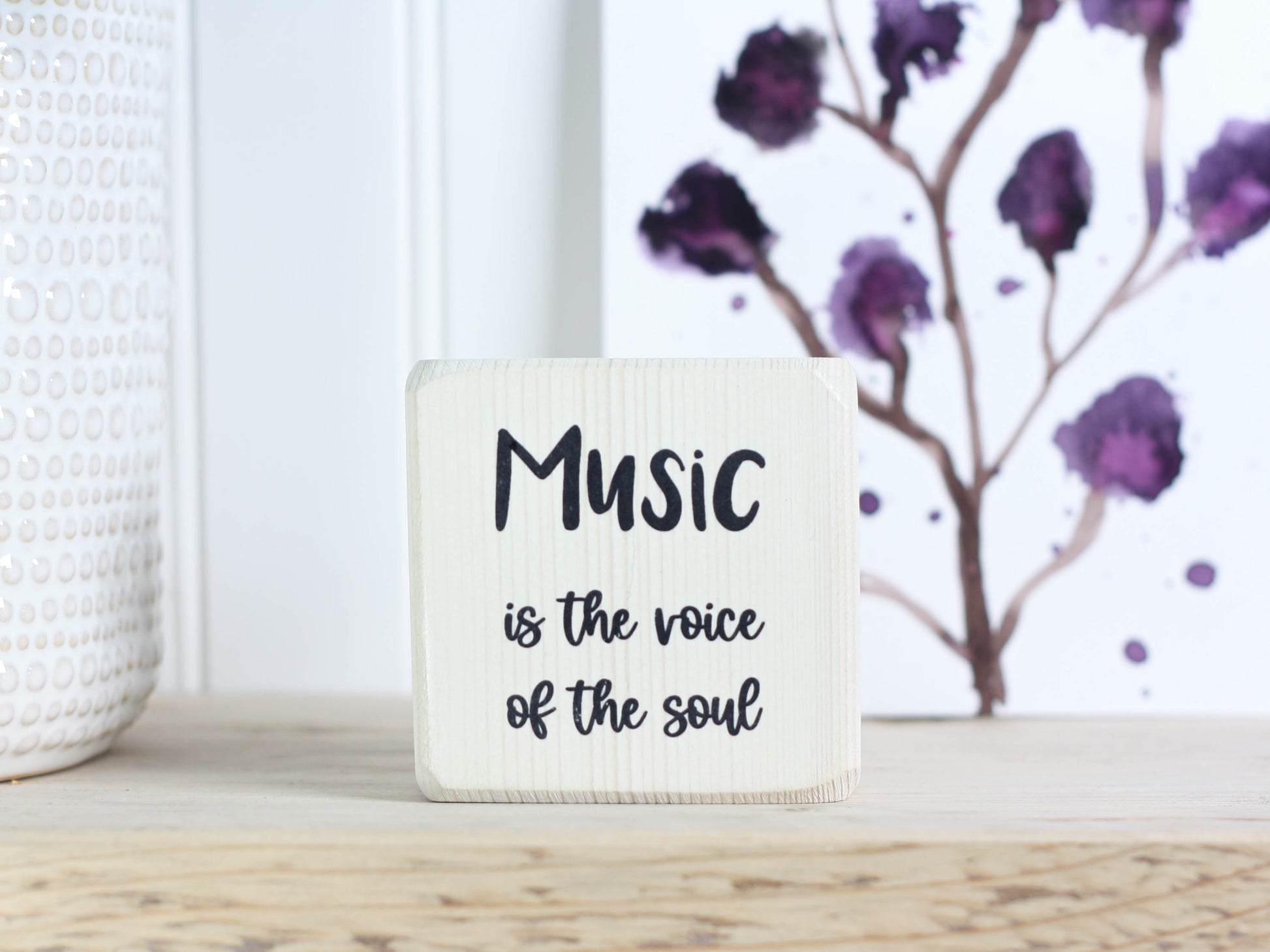 Mini wood sign in whitewash with the saying "Music is the voice of the soul."