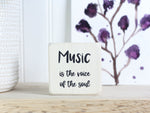 Mini wood sign in whitewash with the saying "Music is the voice of the soul."
