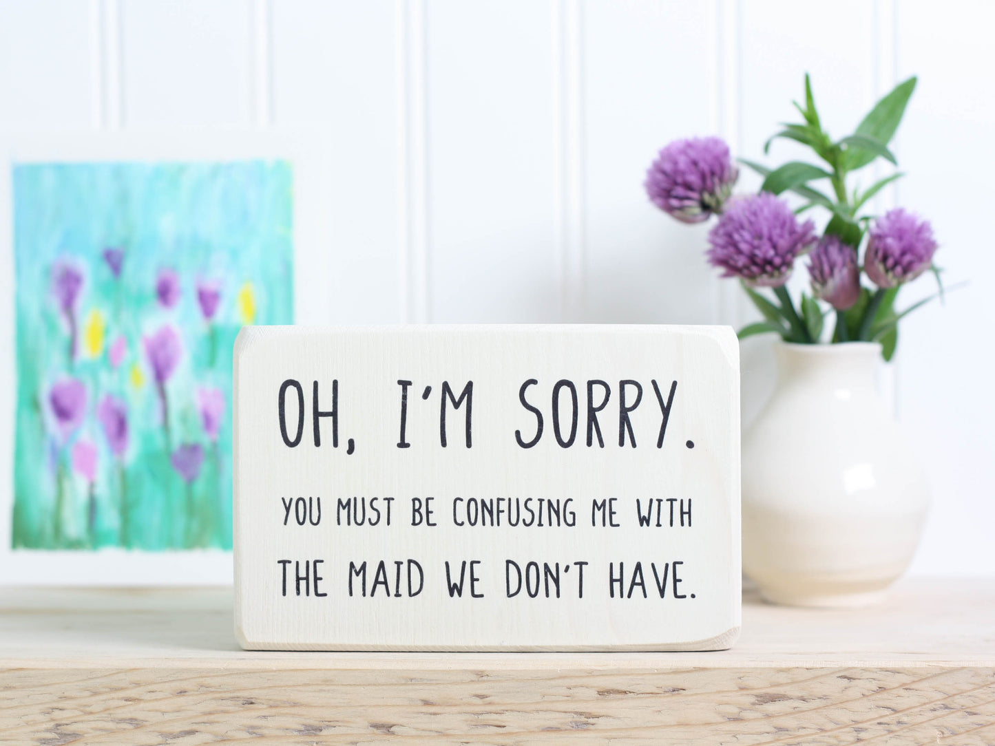 Small wood decor sign in whitewash with the saying "Oh, I'm sorry. You must be confusing me with the maid we don't have."