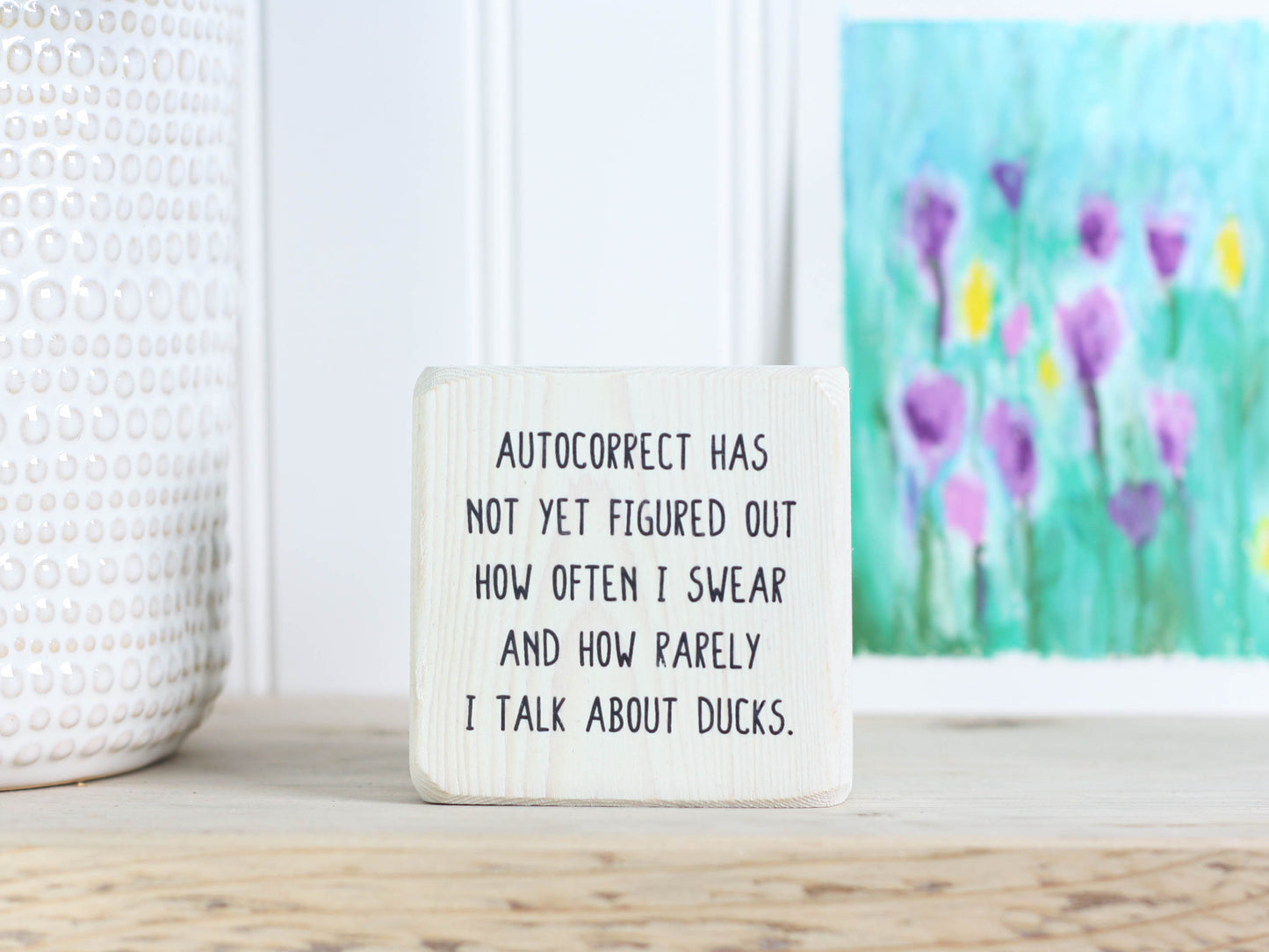 Small, freestanding, whitewash, solid wood sign with saying "autocorrect has not yet figured out how often I swear and how rarely I talk about ducks."