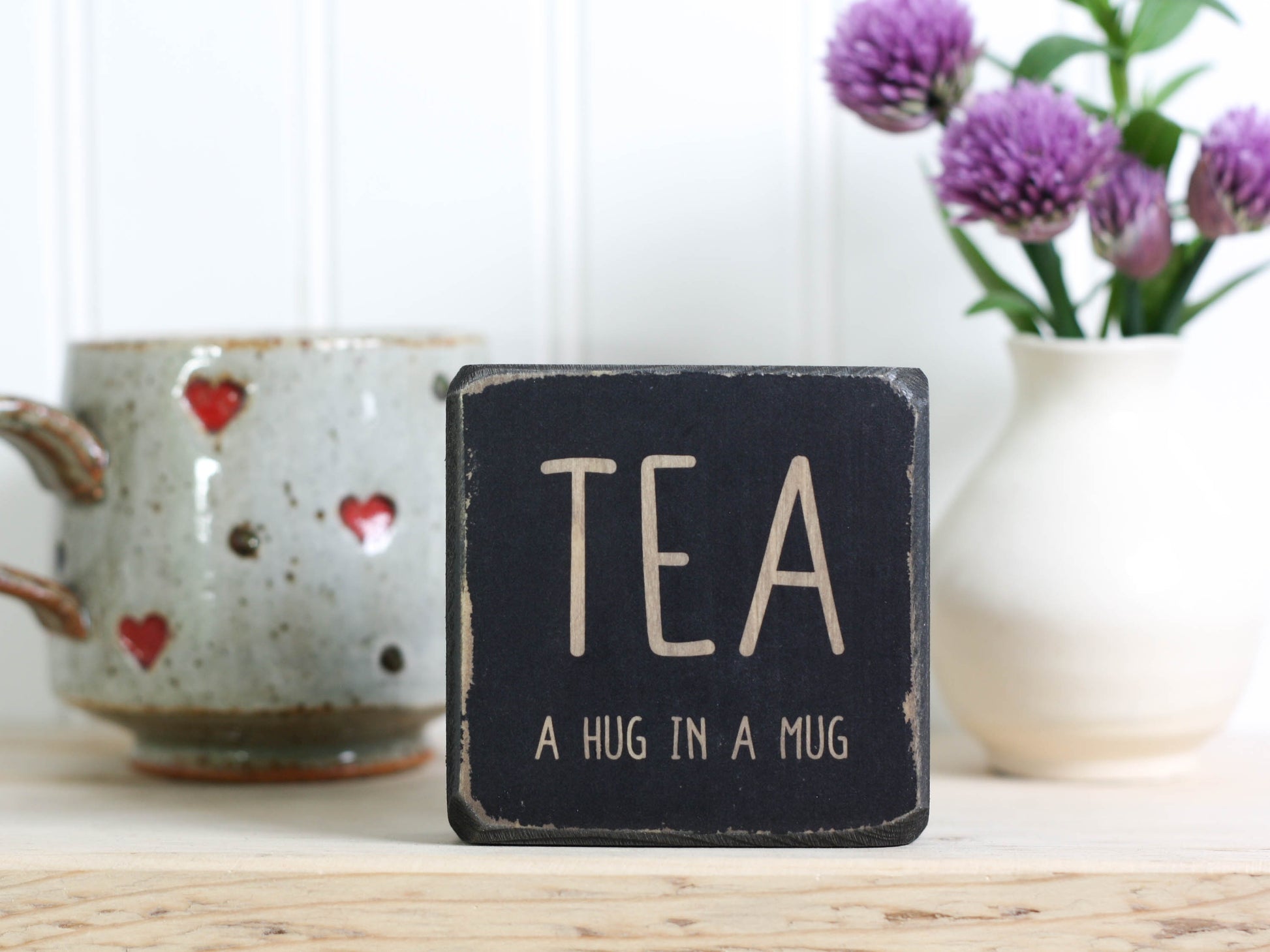 Mini wood sign in distressed black with the saying "TEA a hug in a mug".