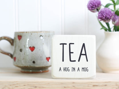 Mini wood sign in whitewash with the saying "TEA a hug in a mug".