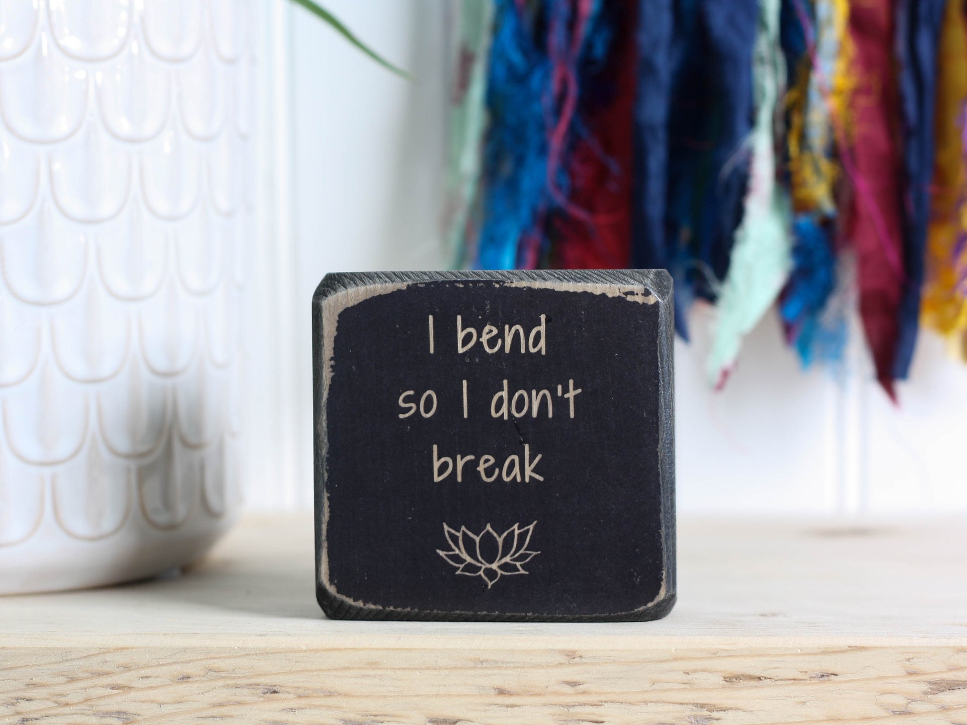 Mini wood yoga decor in distressed black with the saying "I bend so I don't break".