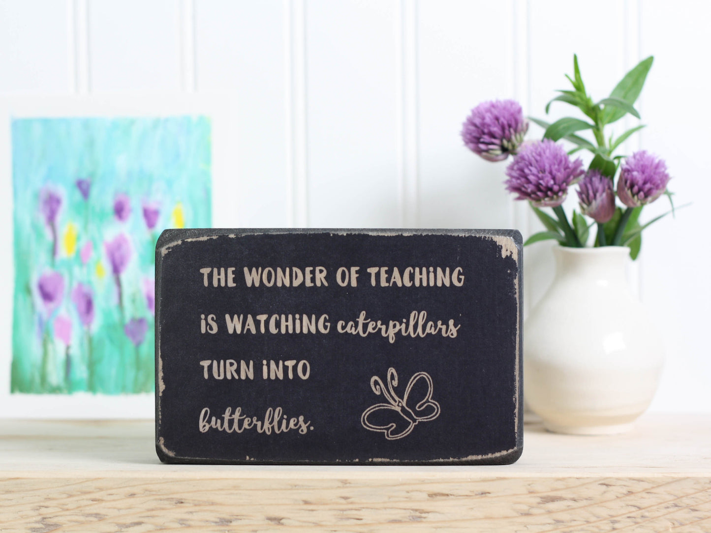 Small wood teacher gift in distressed black with the saying "The wonder of teaching is watching caterpillars turn into butterflies."