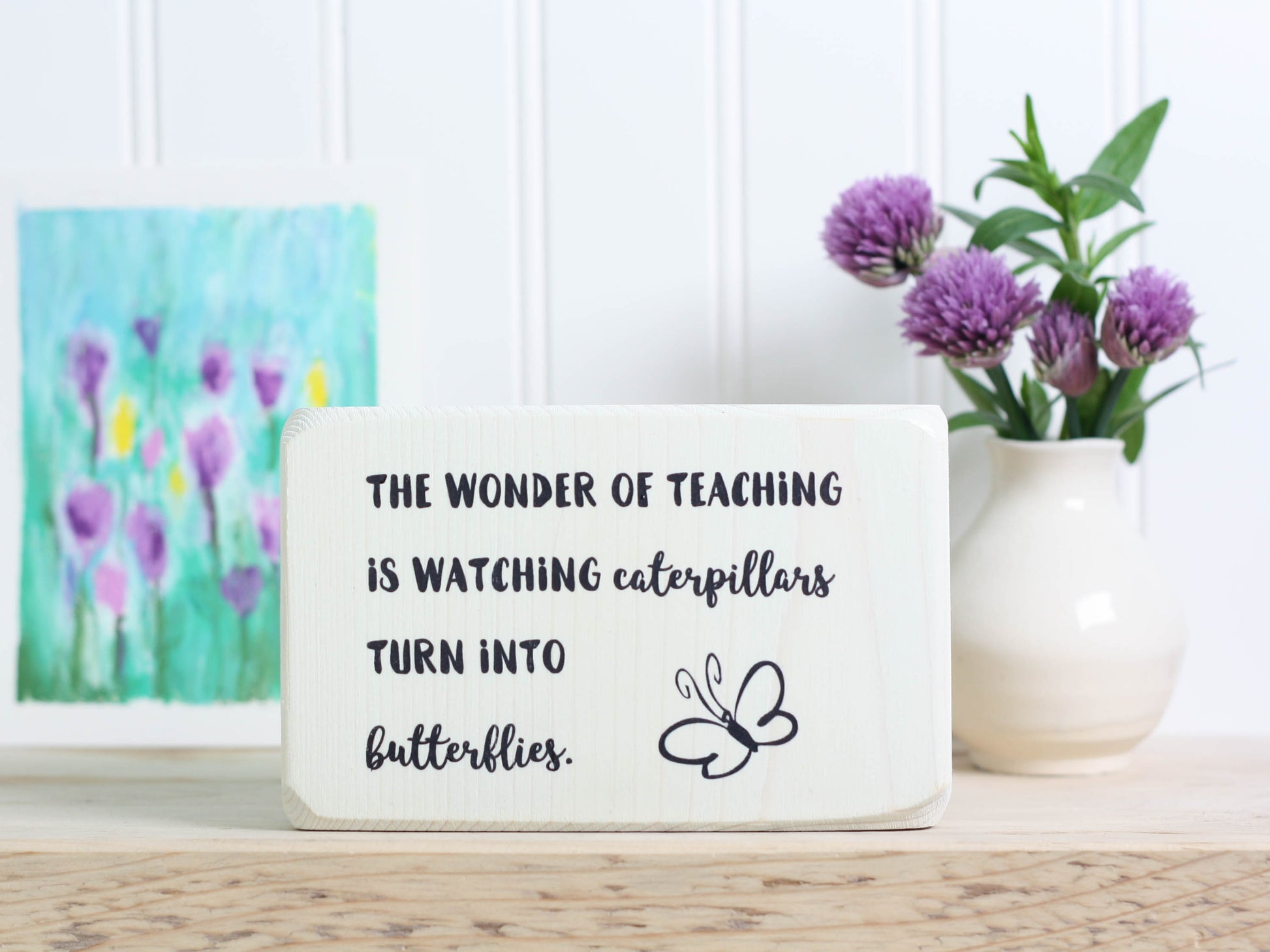 Small wood teacher gift in whitewash with the saying "The wonder of teaching is watching caterpillars turn into butterflies."