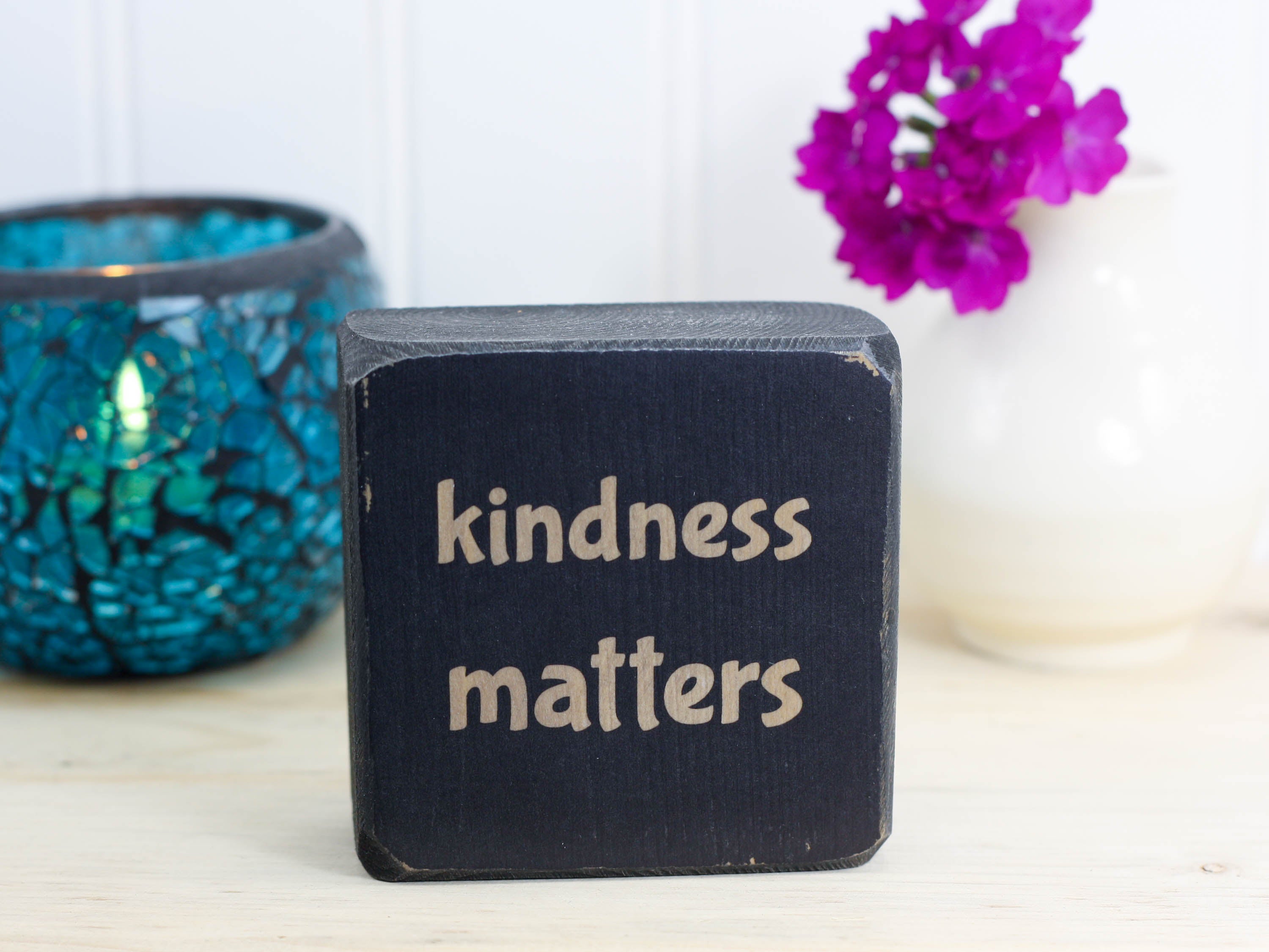 small distressed black sign with the text "kindness matters"
