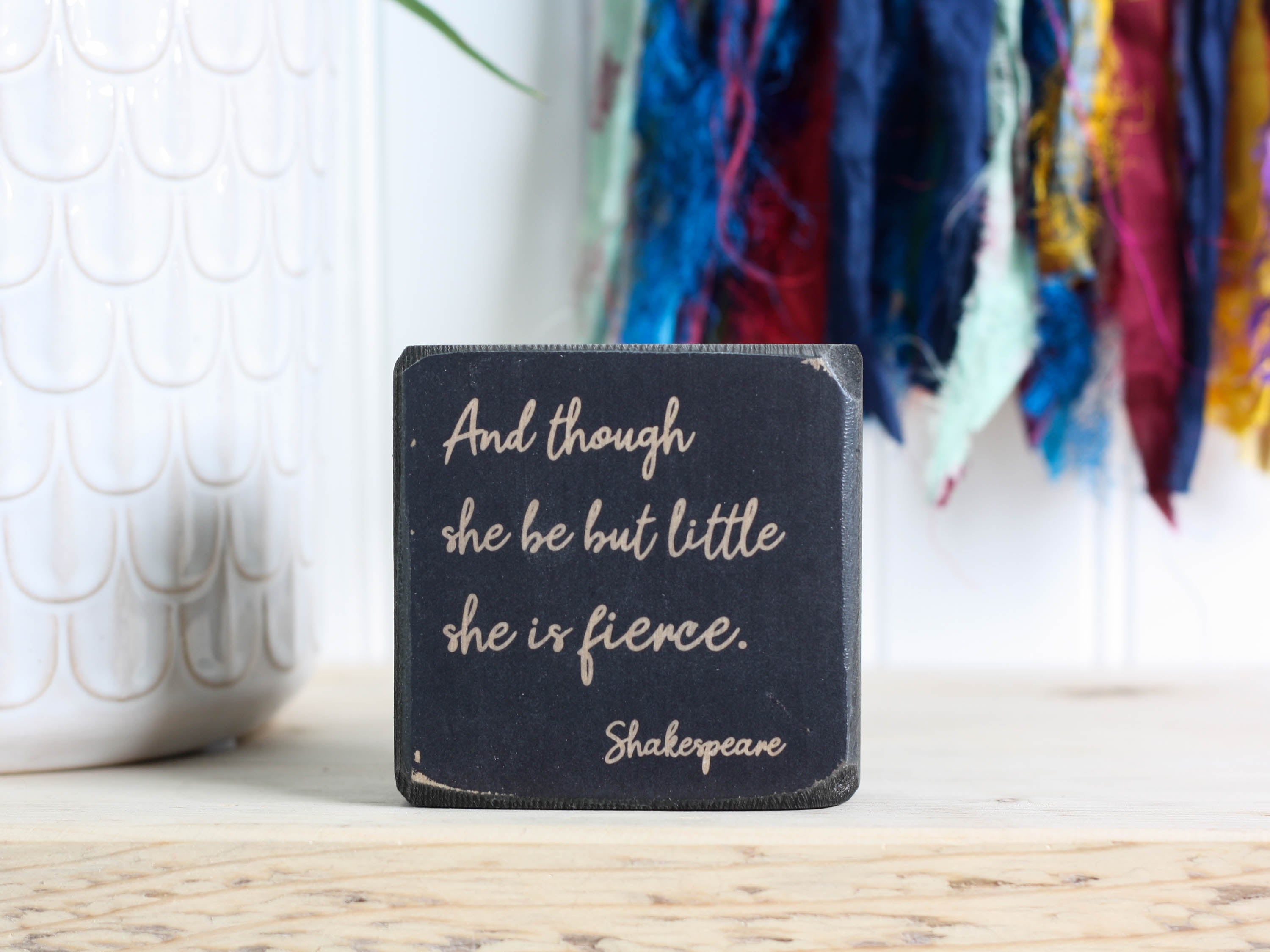 distressed black mini wood sign with the text And though she be but little, she is fierce. - Shakespeare