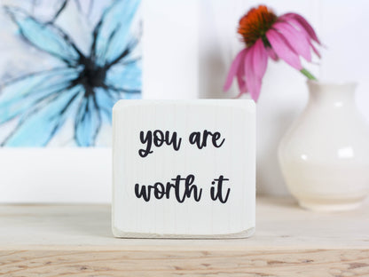 Small, freestanding, distressed black, solid wood sign with saying "you are worth it"