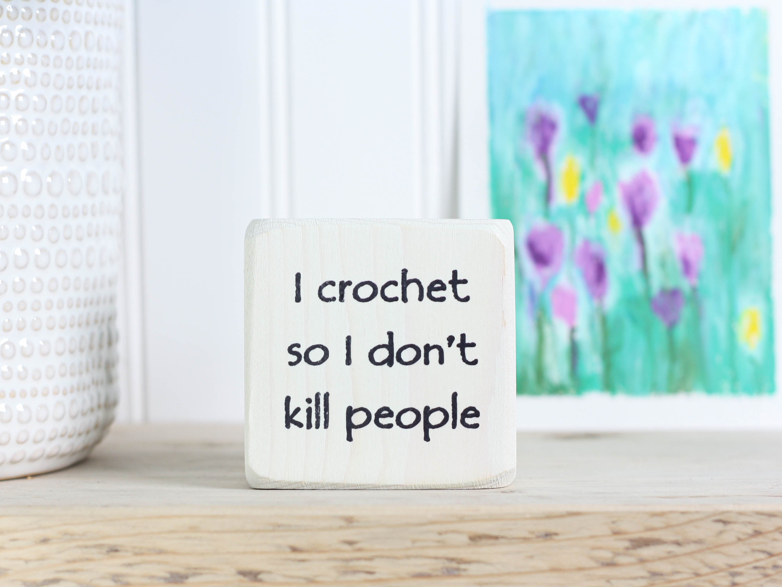 mini wood sign in whitewash with the text "I crochet so I don't kill people"