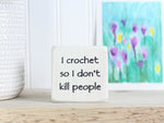 mini wood sign in whitewash with the text "I crochet so I don't kill people"