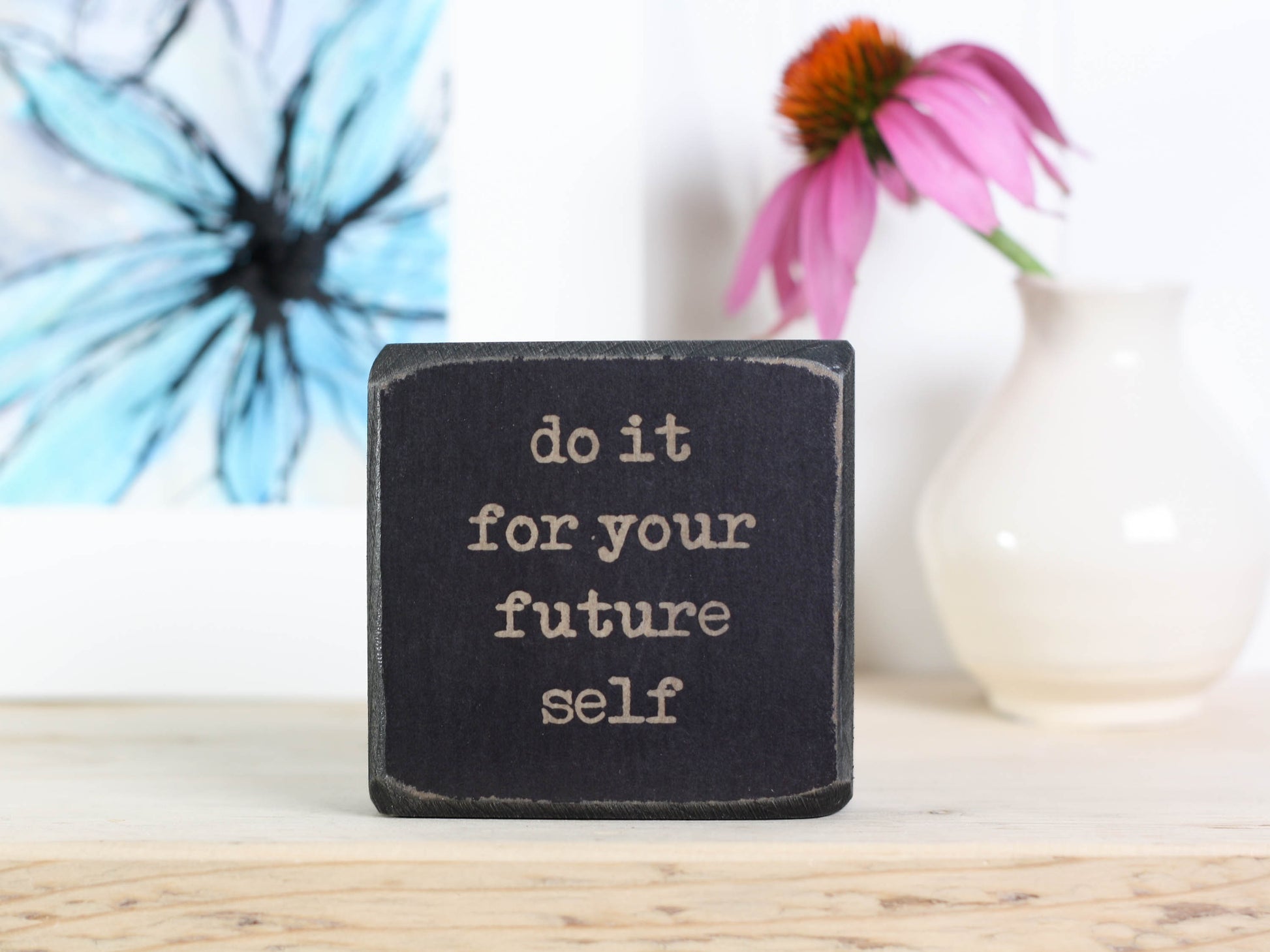 Small, freestanding, distressed black, solid wood sign with saying "do it for your future self".