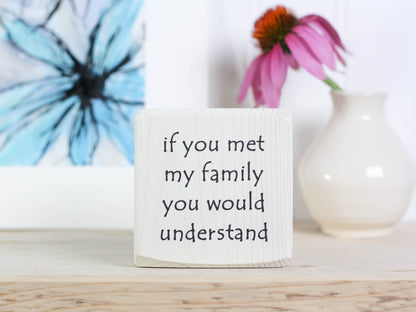 Small wooden sign in whitewash with the saying "If you met my family you would understand".