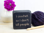mini wood sign in distressed black with the text  "I crochet so I don't kill people"