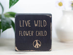 Mini wood desk sign in distressed black with the saying "Live wild flower child".