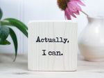 Small motivational wood sign in whitewash with the saying "Actually, I can."