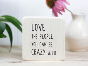 Mini quote block in whitewash with the saying "Love the people you can be crazy with."