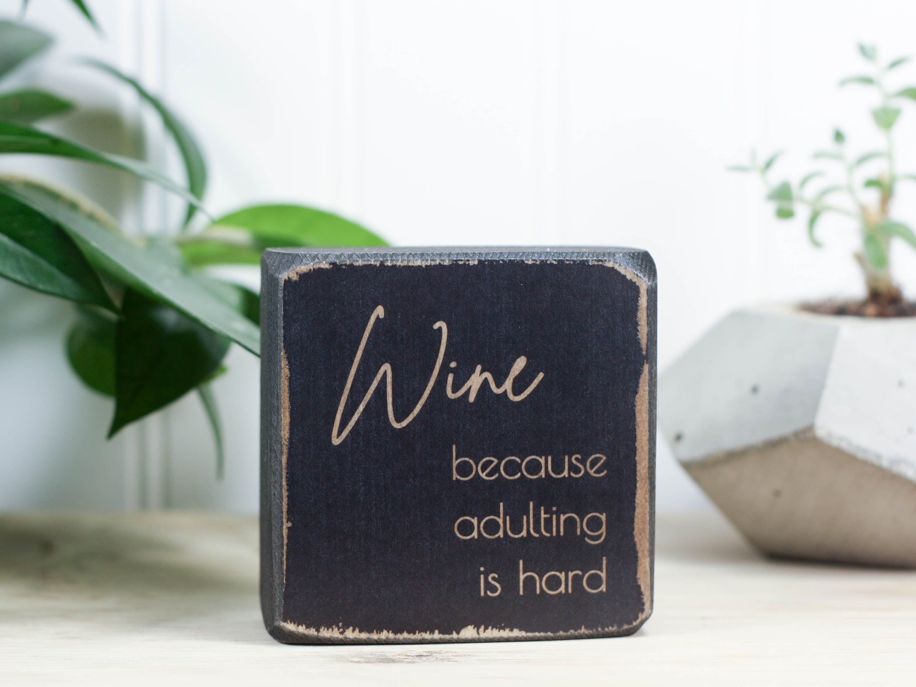 Mini wine bar sign in distressed black with the saying "Wine, because adulting is hard"