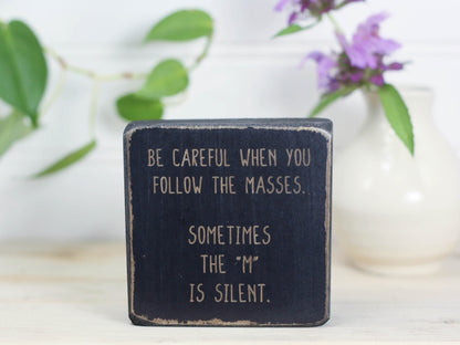 Mini wood shelf decor perfect for the office in distressed black with the saying "Be careful when you follow the masses. Sometimes the "m" is silent."