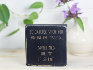 Mini wood shelf decor perfect for the office in distressed black with the saying "Be careful when you follow the masses. Sometimes the "m" is silent."