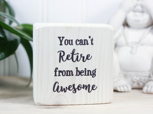 Mini wood sign in whitewash with the saying "You can't retire from being awesome".