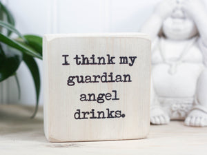 Mini wood sign in whitewash with the saying "I think my guardian angel drinks." Funny home decor.