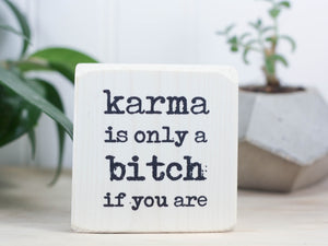 Small but sassy freestanding decor in whitewash with the saying "Karma is only a bitch if you are".