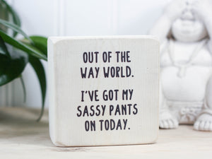 Mini wood sign in whitewash with the saying "Out of the way world. I've got my sassy pants on today."