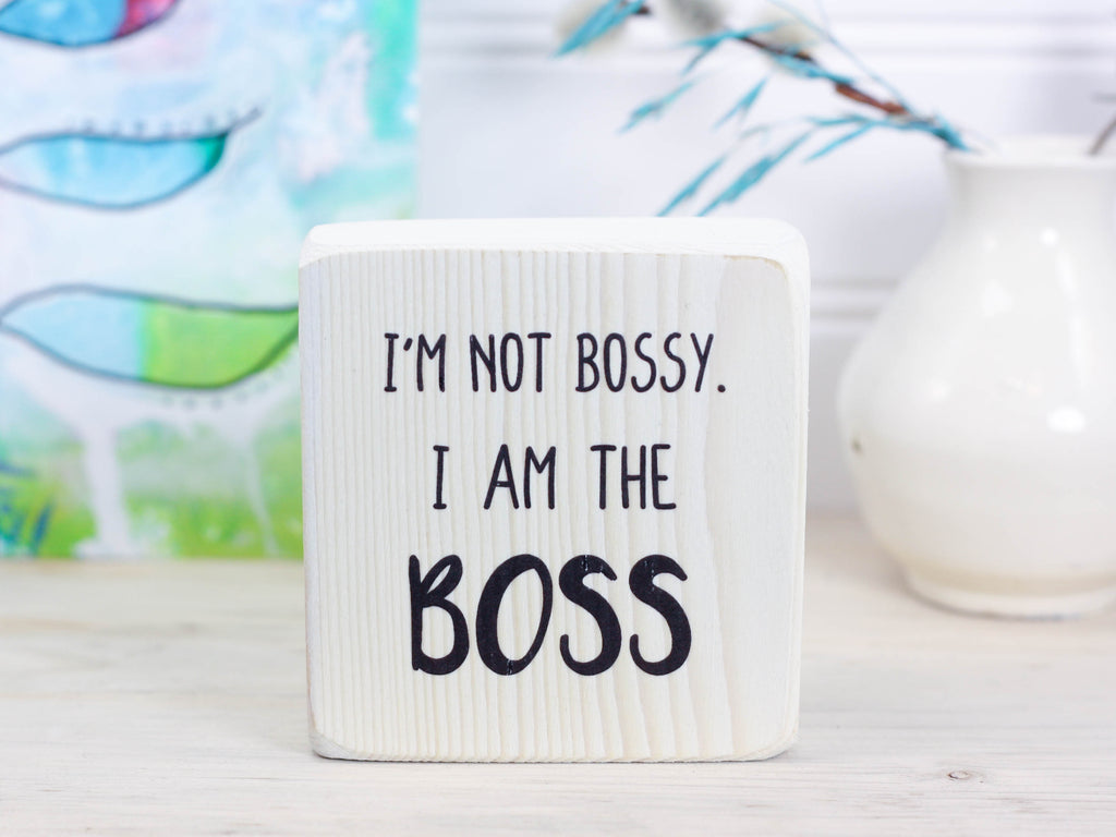 Small whitewash freestanding wood sign with the text "I'm not bossy. I am the boss"