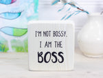 Small whitewash freestanding wood sign with the text "I'm not bossy. I am the boss"