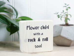 Small, freestanding, whitewash, solid wood sign with saying "Flower child with a rock & roll soul".