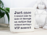 Small funny desk sign in whitewash with the saying "Just once I would like to make it through an entire day without having a WTF moment."