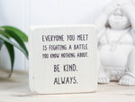 Small freestanding wood decor in whitewash with the saying "Everyone you meet is fighting a battle you know nothing about. Be kind. Always"
