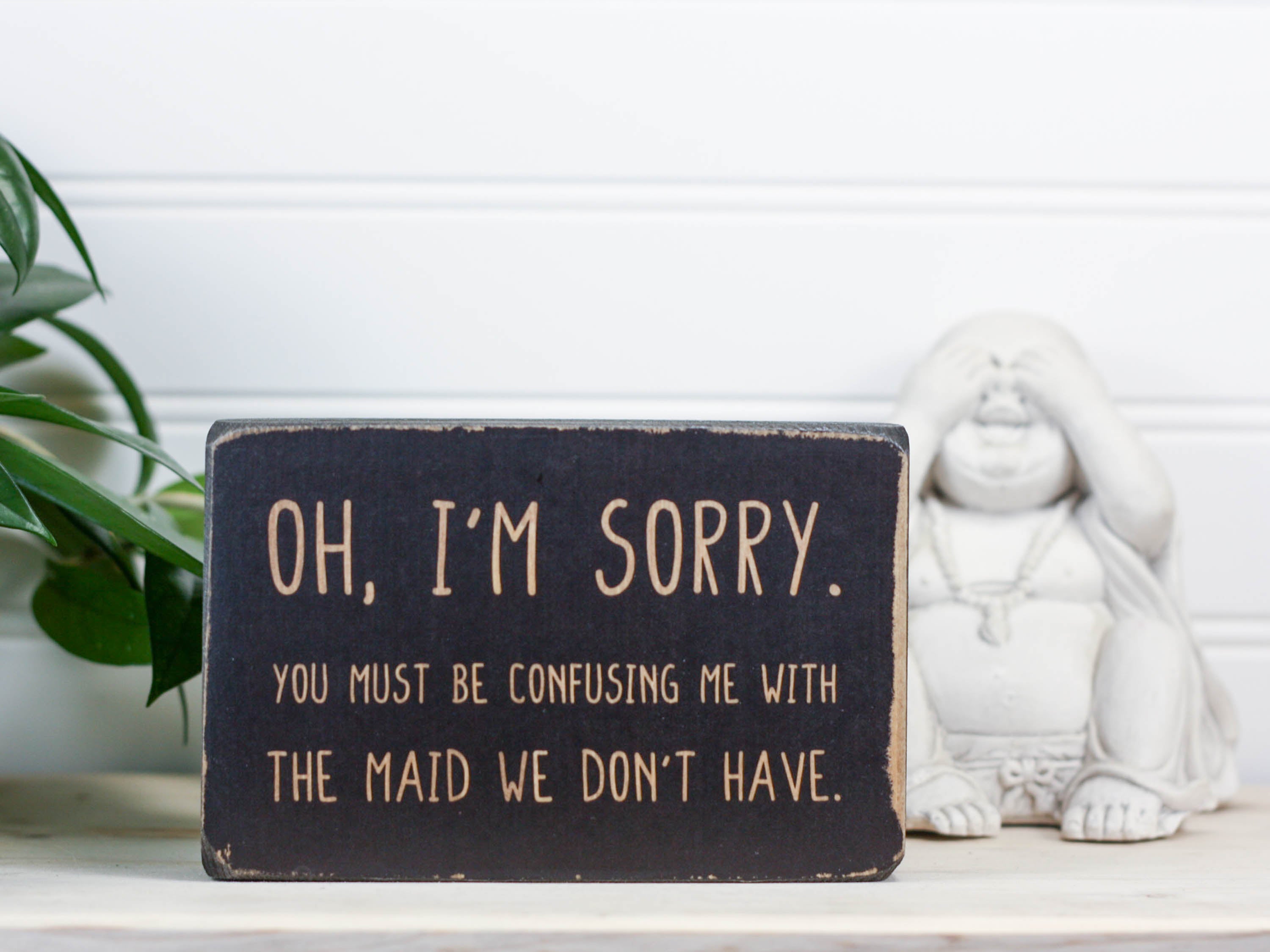 Small wood decor sign in distressed black with the saying "Oh, I'm sorry. You must be confusing me with the maid we don't have."