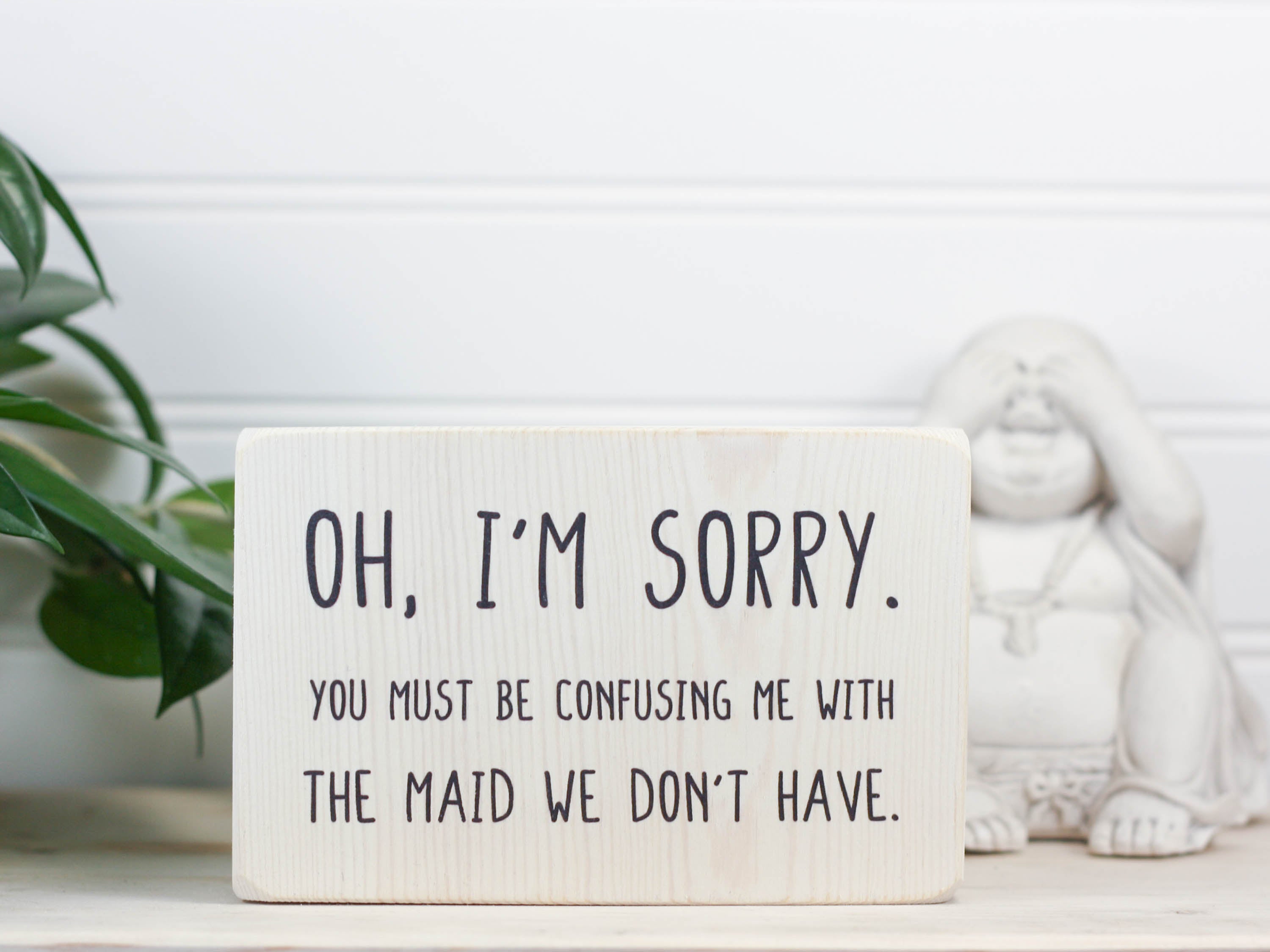 Small wood decor sign in whitewash with the saying "Oh, I'm sorry. You must be confusing me with the maid we don't have."