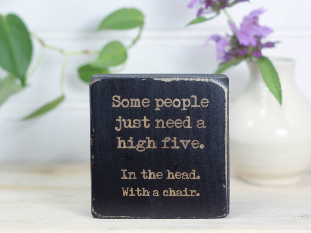 Small wood funny sign in distressed black with the saying "Some people just need a high five. In the head. With a chair."