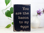 Small wood romance sign in distressed black with the saying "You are the bacon to my eggs".