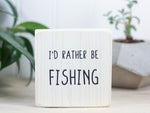 Mini wood sign in whitewash with the saying "I'd rather be fishing."