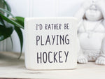 Mini wood sign in whitewash with the saying "I'd rather be playing hockey".