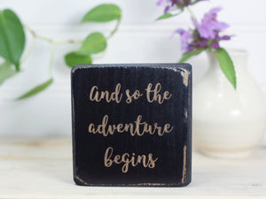Freestanding decor block makes the perfect gift for the adventurer in your life. Distressed black with the saying "and so the adventure begins".