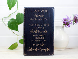 Small wood sign in distressed black with the saying "I hope we're friends until we die. And then I hope we stay ghost friends and walk through walls and scare the shit out of people."