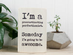 Small wood sign in whitewash with the saying "I'm a procrastinating perfectionist. Someday I'm going to be awesome."